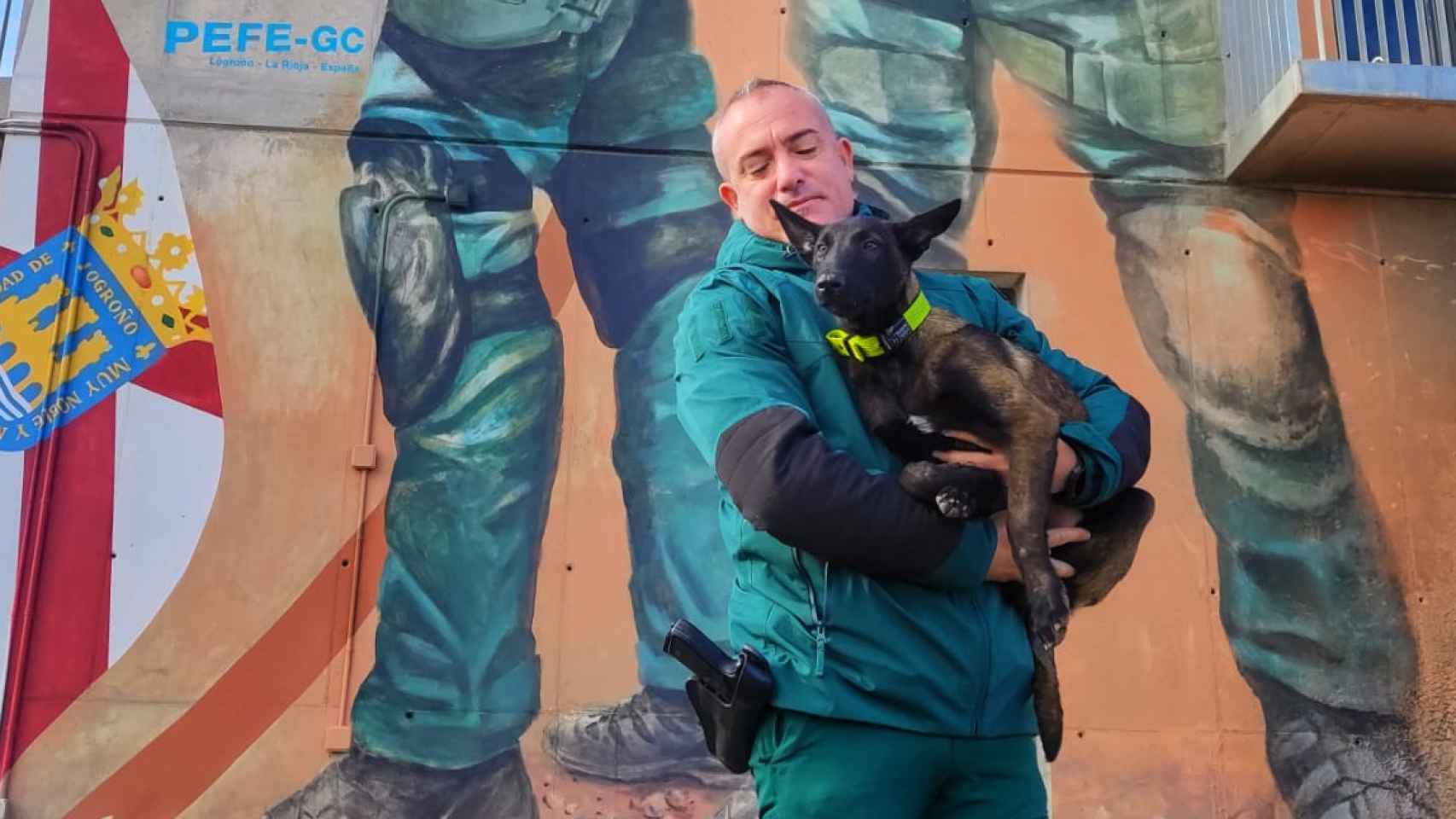 El agente de la Guardia Civil Iván García sostiene a un perro entre sus brazos.
