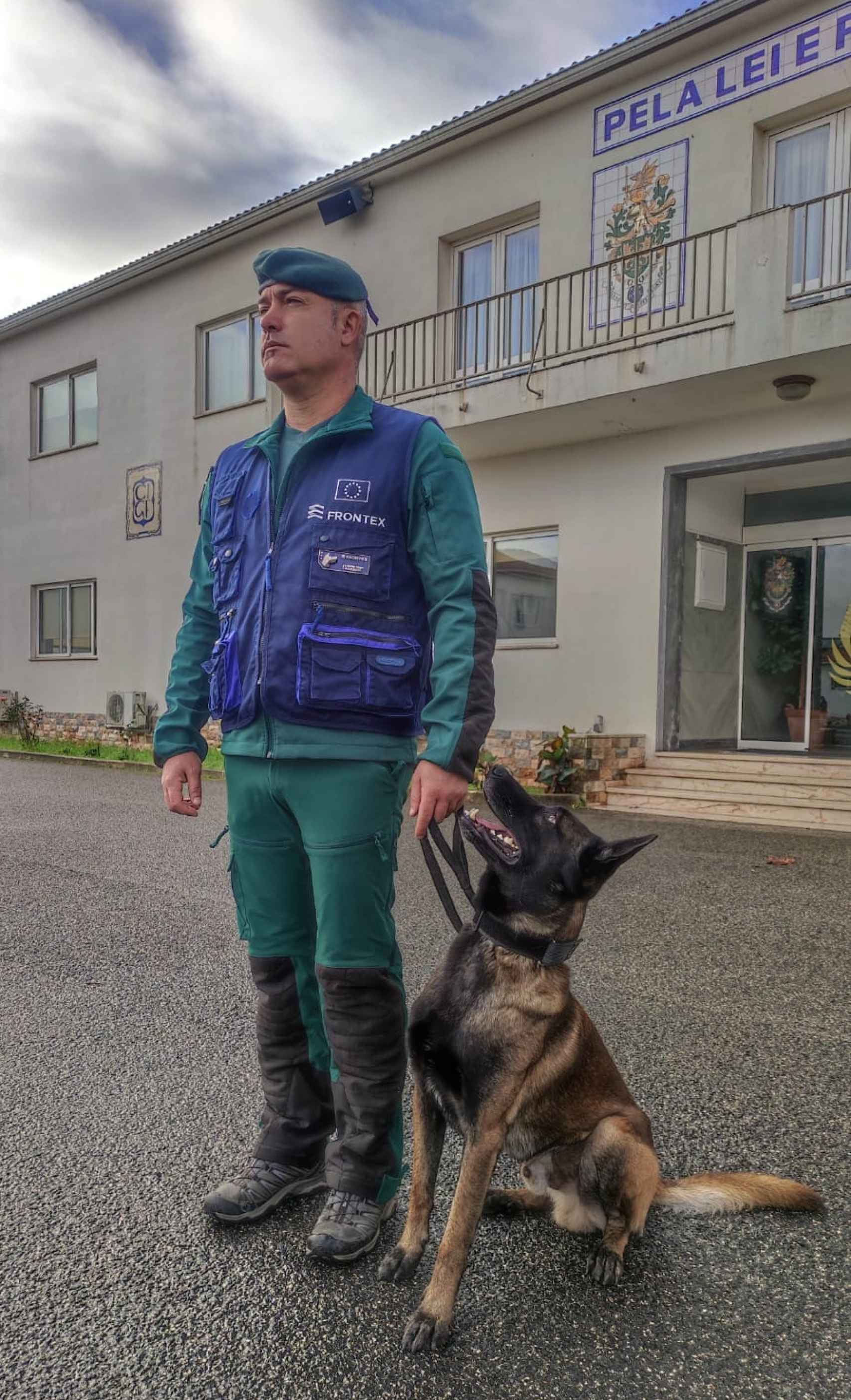 El agente Iván García, con el uniforme de Frontex, posa junto a un perro policía.