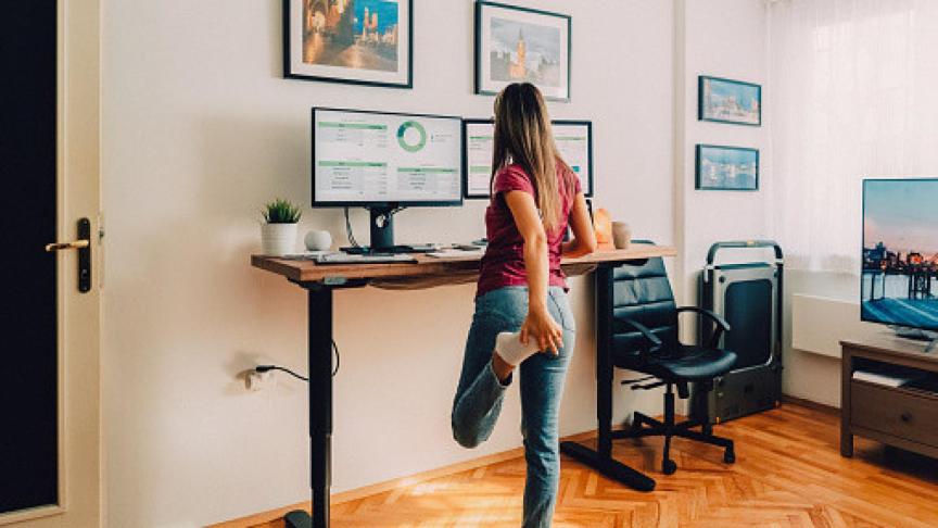 Una mujer teletrabajando y haciendo ejercicio.