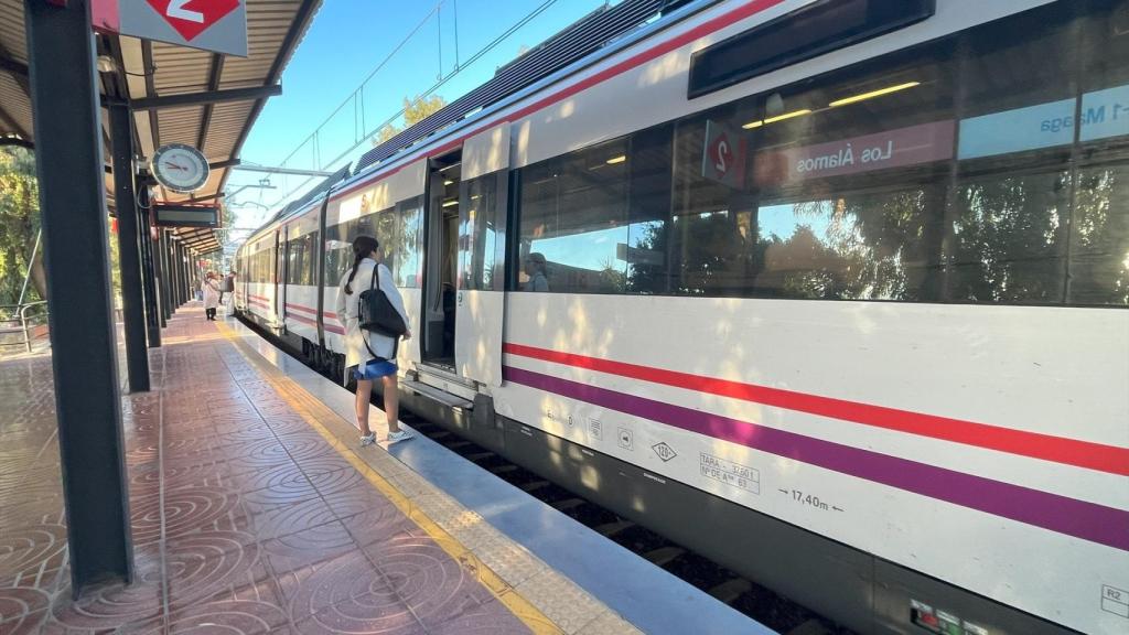 Una persona sube a un tren de Cercanías.