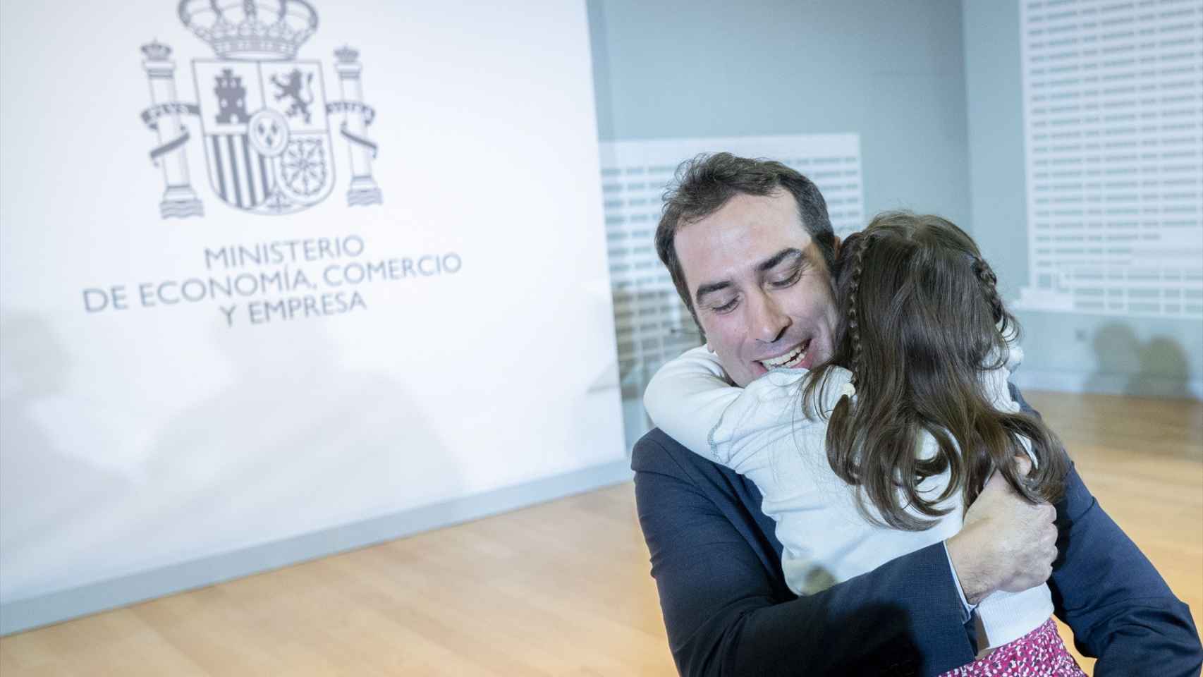 El nuevo ministro de Economía, Comercio y Empresa, Carlos Cuerpo, abraza a su hija durante el acto de traspaso de la cartera de Economía, Comercio y Empresa.