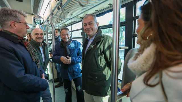 El alcalde de Sevilla, junto al director territorial de Caixabank y el gerente de Tussam, en el interior de un autobús.