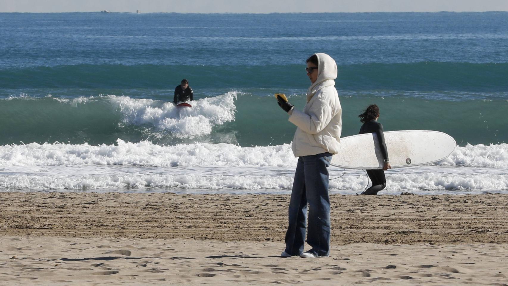 Unos surfistas en el agua en la Playa de la Malvarrosa de Valencia.