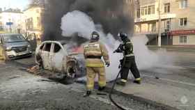 Los bomberos tratan de apagar un coche en llamas tras un bombardeo en Bélgorod.