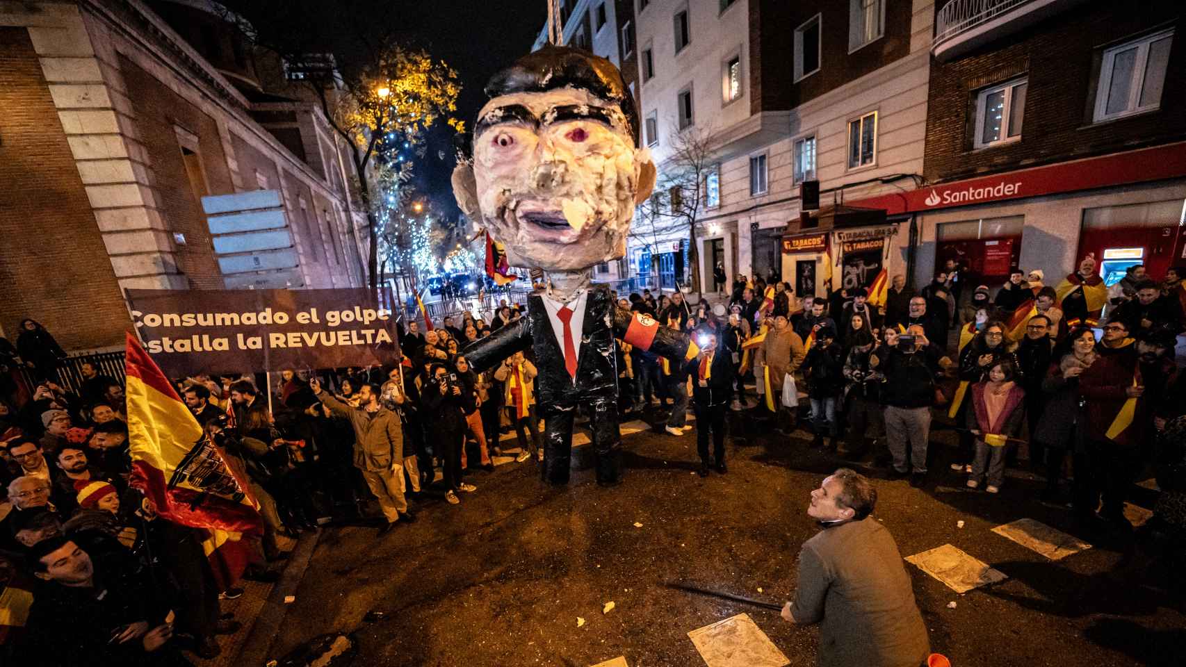 Manifestantes golpean una efigie de Pedro Sánchez a la entrada de la calle Ferraz.