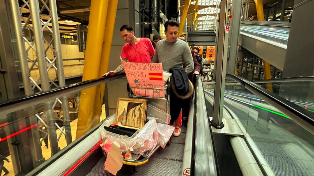 Pambu, junto a varios de sus familiares, con una pancarta de bienvenida.