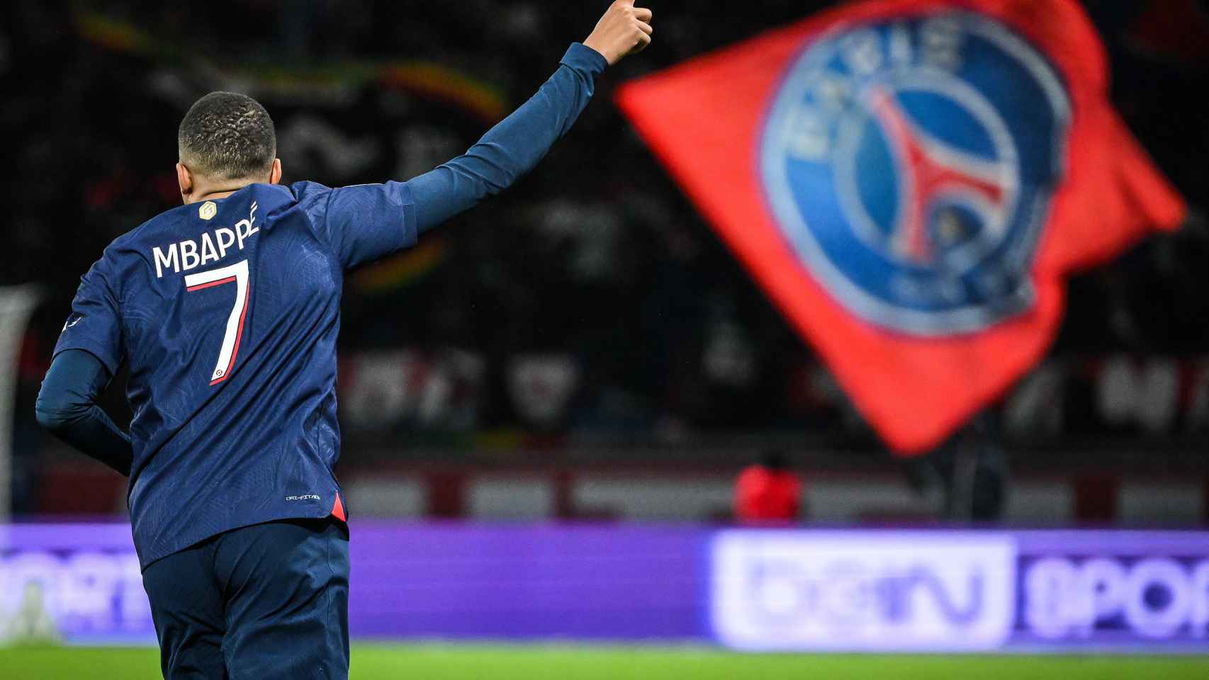 Kylian Mbappé celebra un gol con una bandera del PSG de fondo