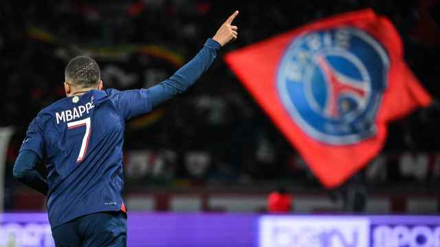 Kylian Mbappé celebra un gol con una bandera del PSG de fondo