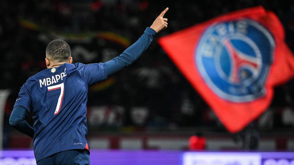 Kylian Mbappé celebra un gol con una bandera del PSG de fondo