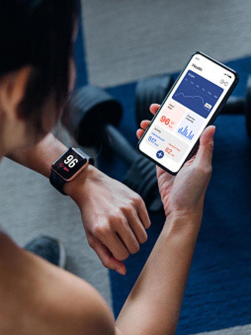 Una mujer calculando su pulso a través de una aplicación.