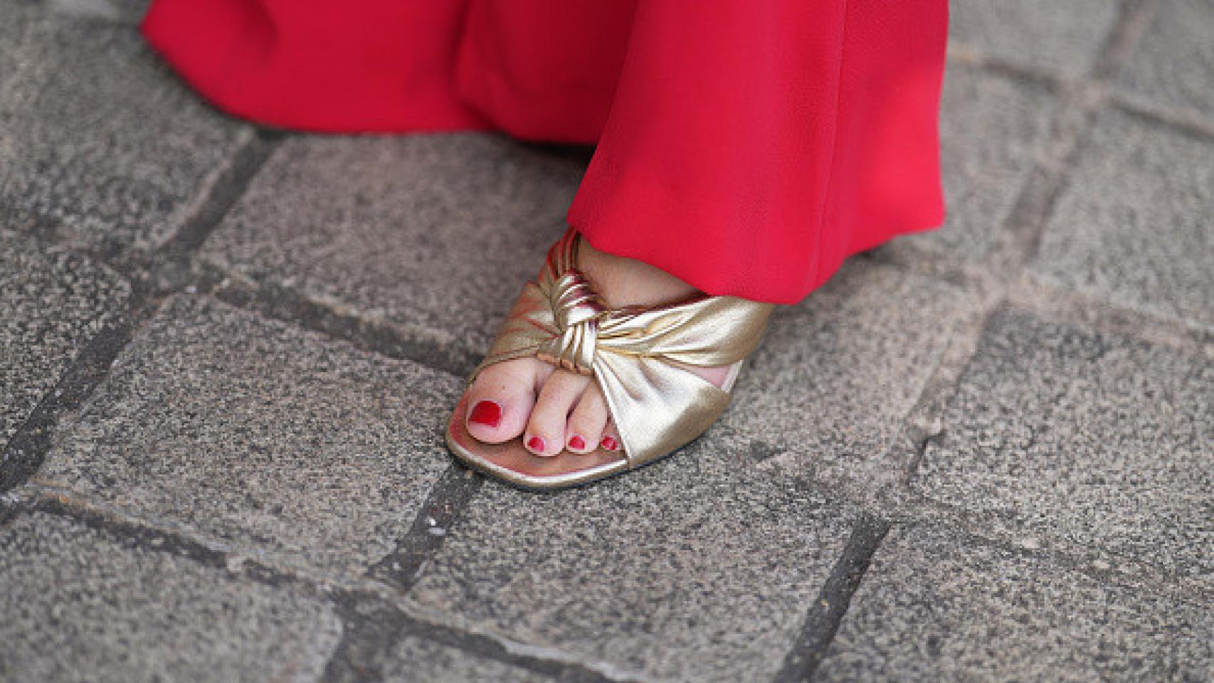 Detalle de sandalias doradas en el 'street style'.