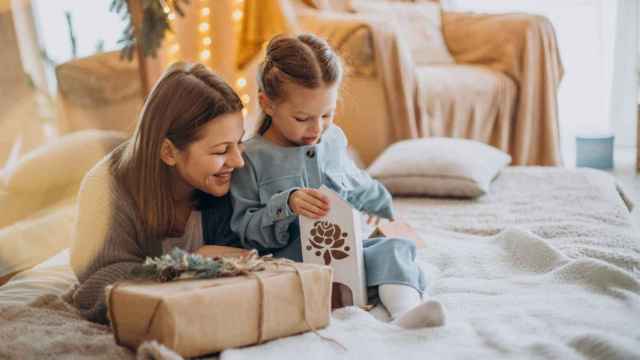 Madre junto a su hija abriendo regalos.