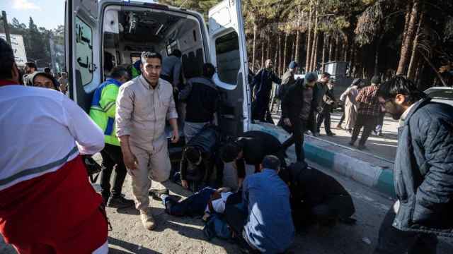 Varias personas ayudando a una víctima de las explosiones junto a una ambulancia. Kerman, Irán, este miércoles.