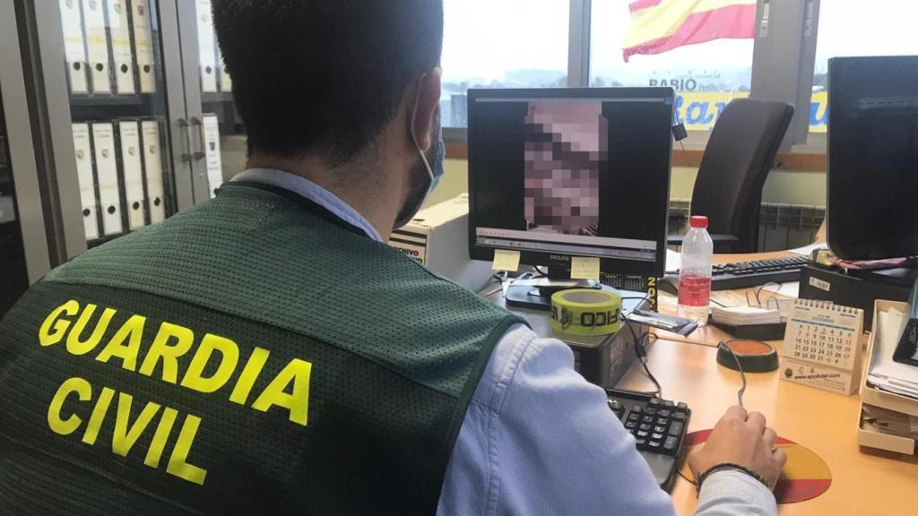 Un agente de la Guardia Civil peritando el contenido pornográfico incautado en una imagen de archivo.