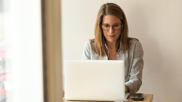 Una mujer, consultando su portátil.