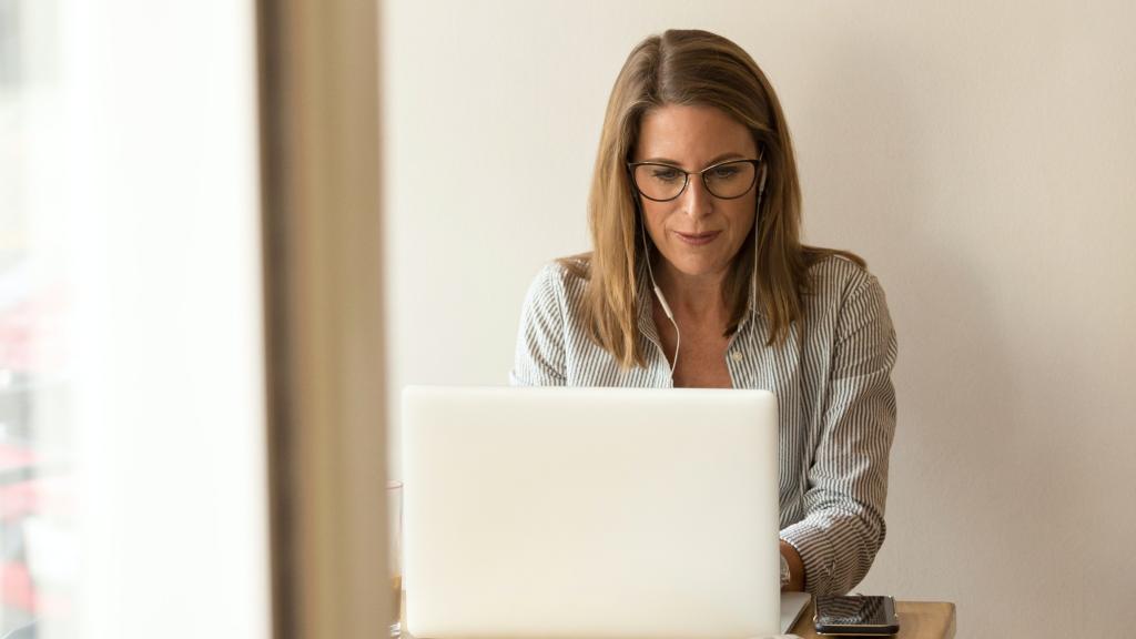 Una mujer, consultando su portátil.
