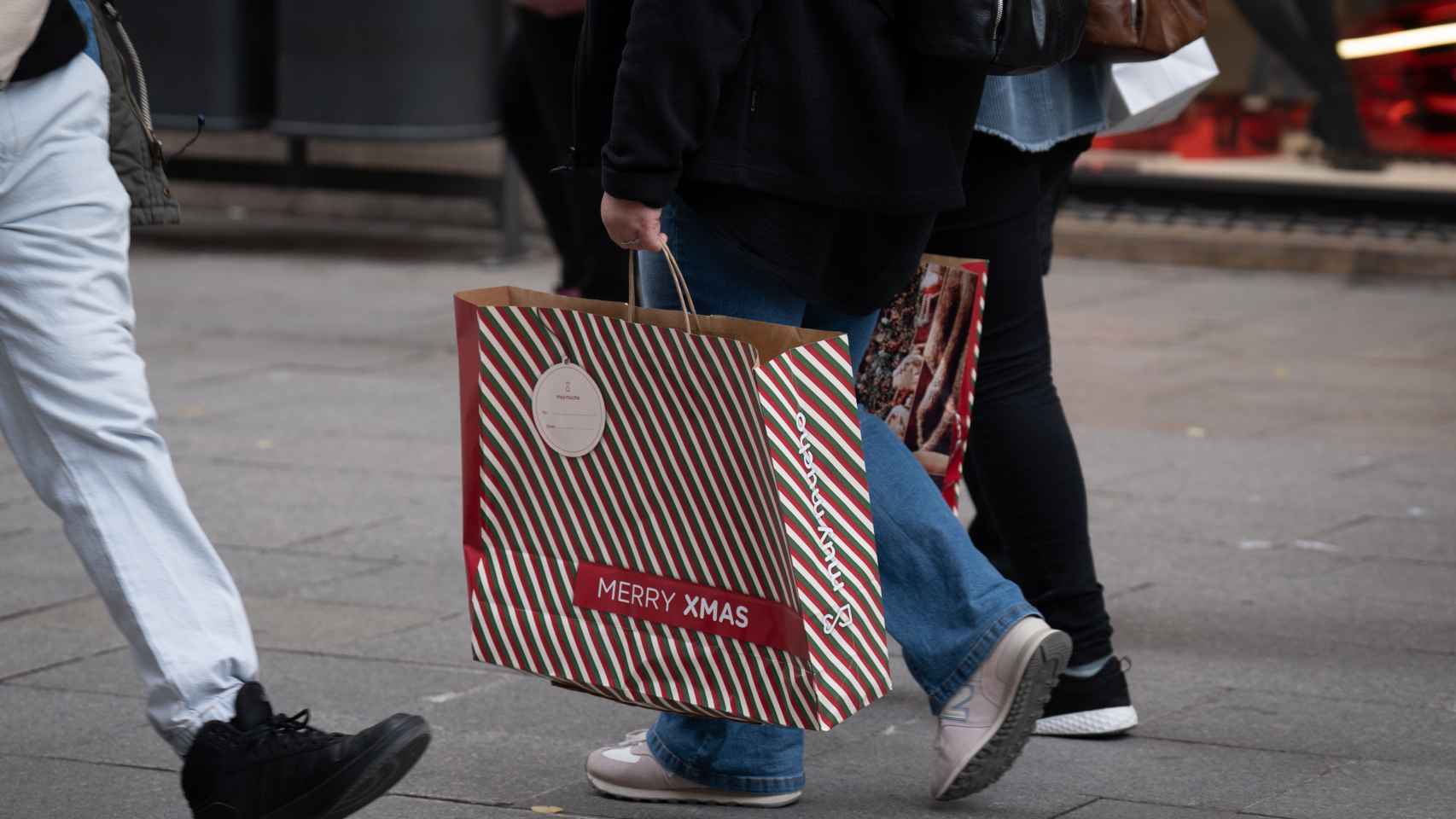 Una persona sujeta bolsas con compras durante la campaña de Navidad