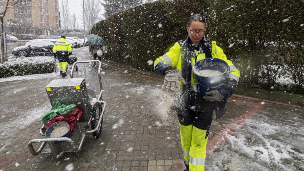 Una mujer echa sal a una calle nevada de Valladolid.