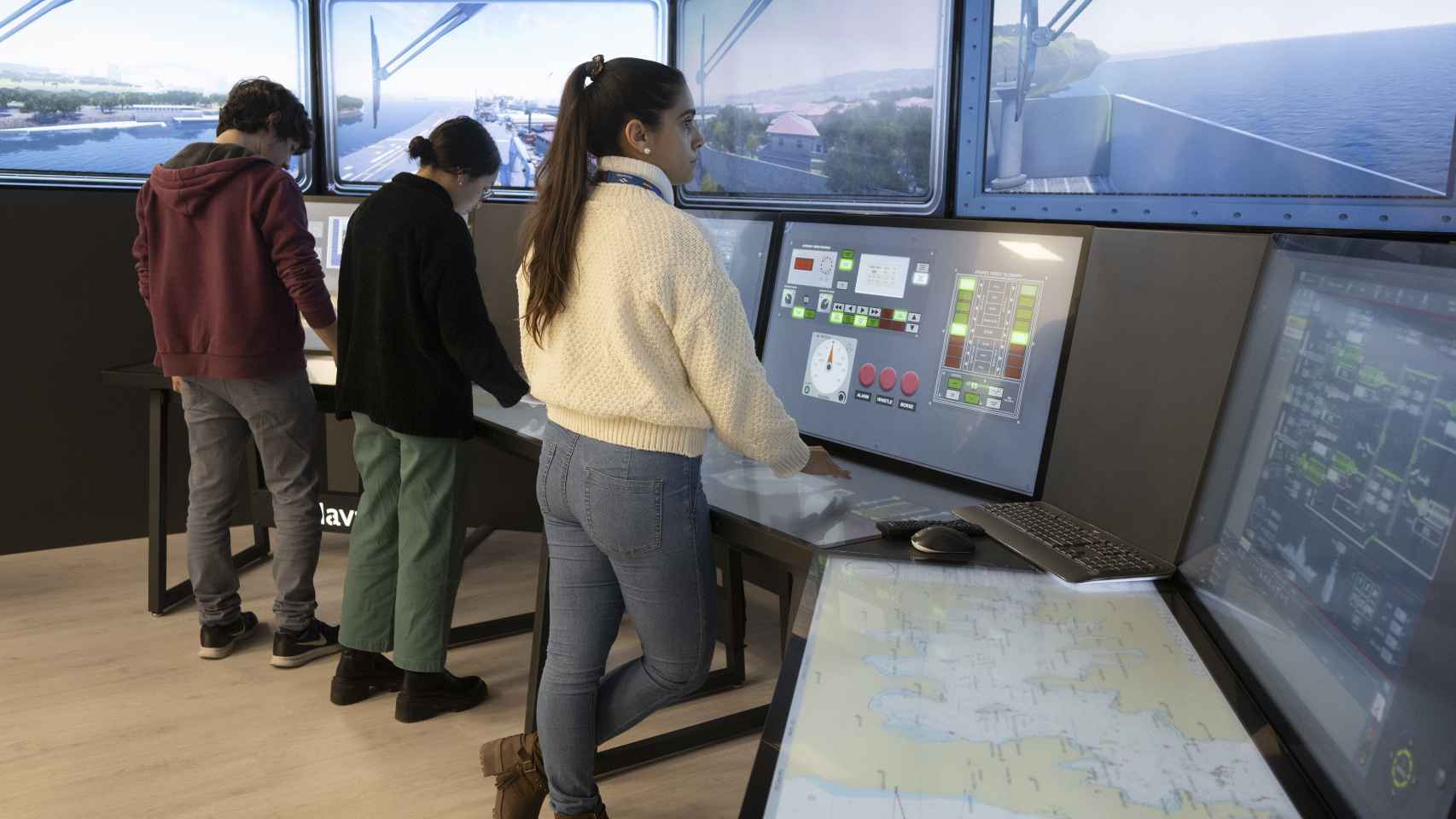 Jovencísimos ingenieros de Sistemas, manejando el simulador del control del sistema de buques.