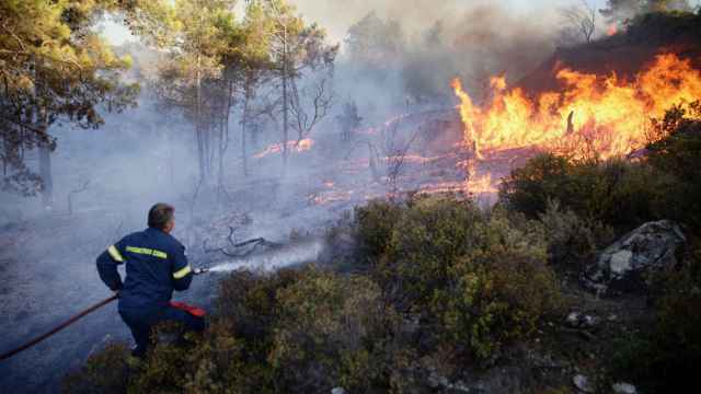 Un bombero intenta apagar un incendio forestal en la aldea de Asklipio (Rodas, Grecia) a 23 de julio de 2023.