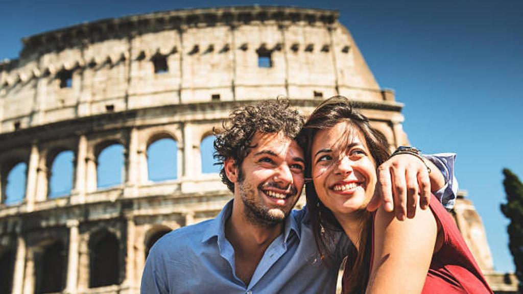 Dos personas frente al Coliseo Romano