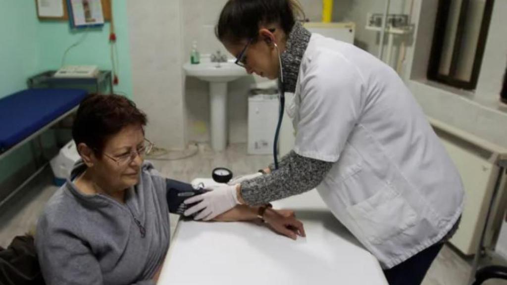 Una doctora le toma la tensión a una paciente en un centro de salud