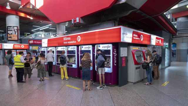 Varias personas en las taquillas de venta automática de billetes en la estación de tren de Atocha