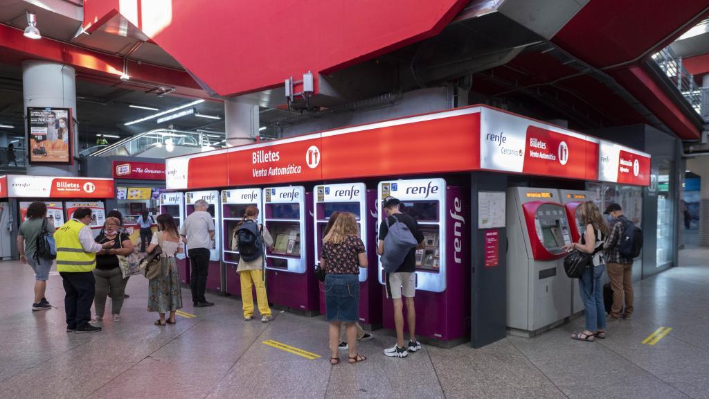 Varias personas en las taquillas de venta automática de billetes en la estación de tren de Atocha