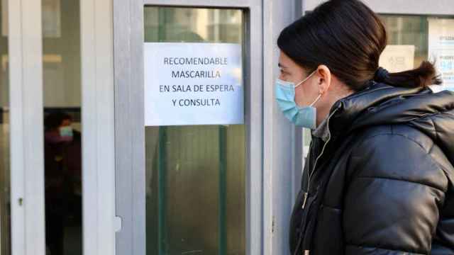 Una persona entra en un centro de salud con mascarilla.