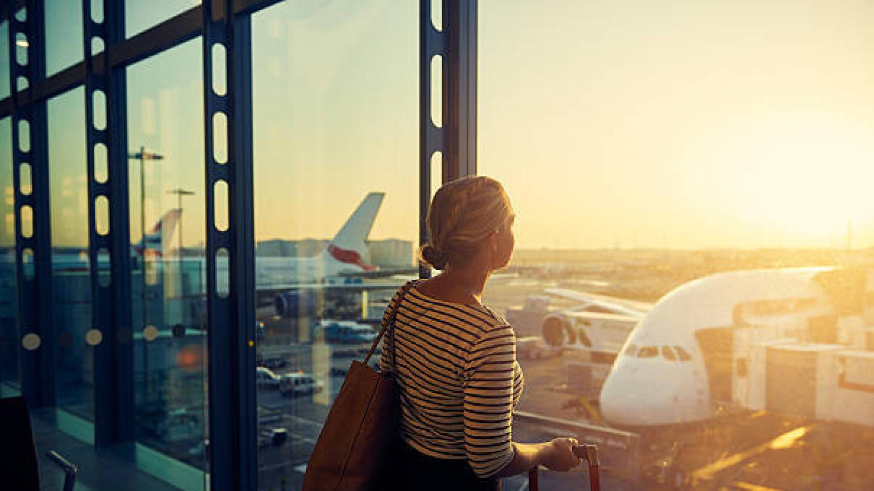 Una mujer espera un vuelo en un aeropuerto.