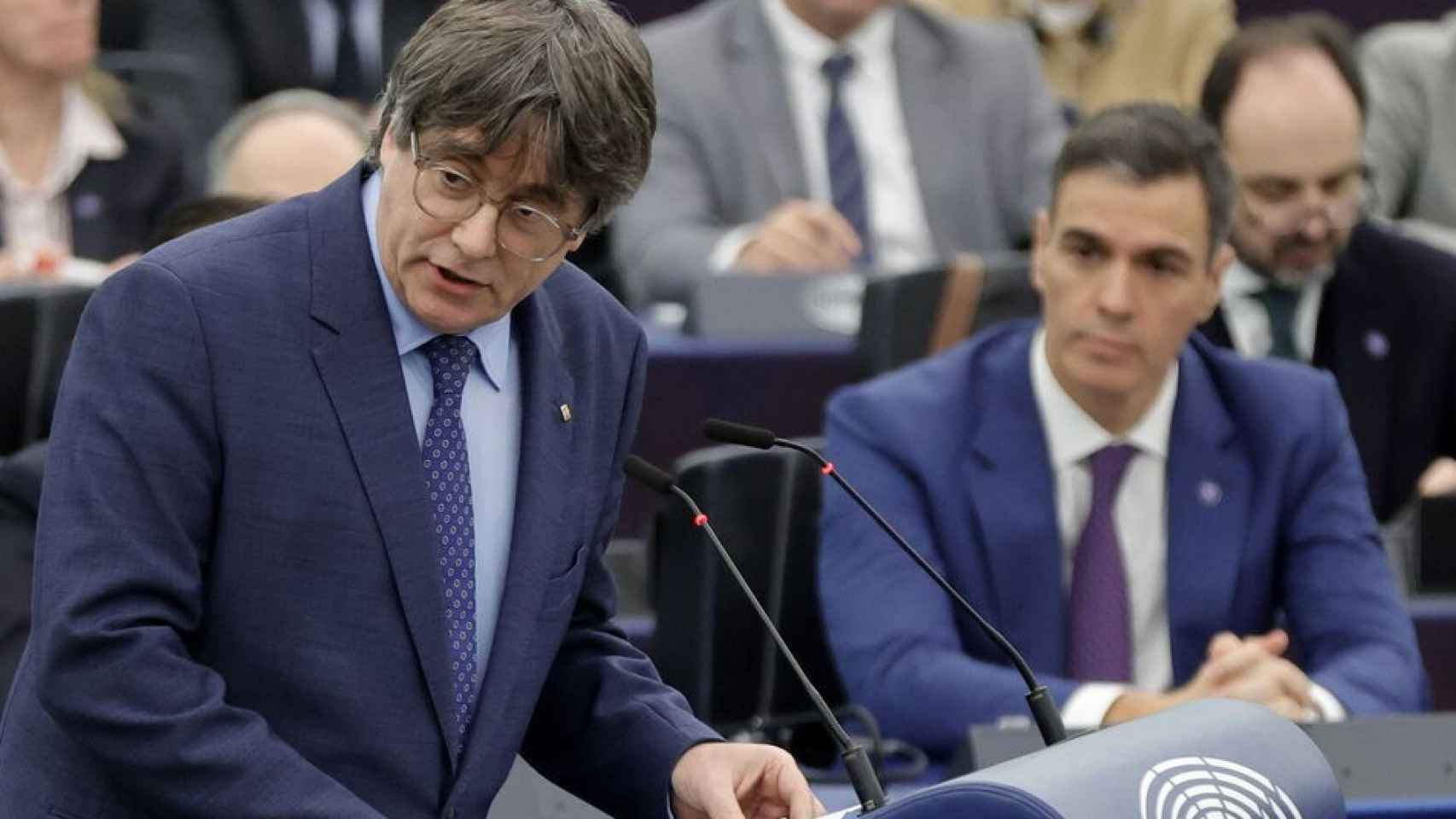 Carles Puigdemont, en el Parlamento Europeo; al fondo, Pedro Sánchez, el pasado mes de diciembre.