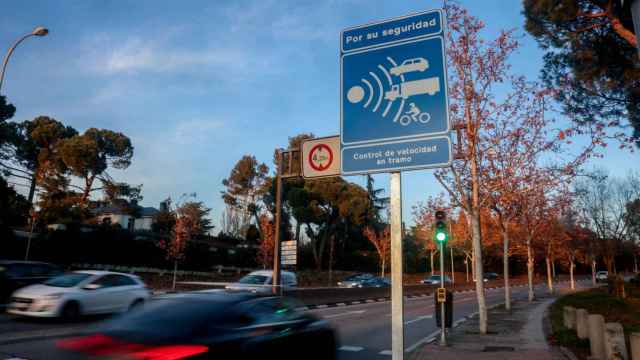 Varios coches pasan junto a una señal de radar de tramo en Madrid.