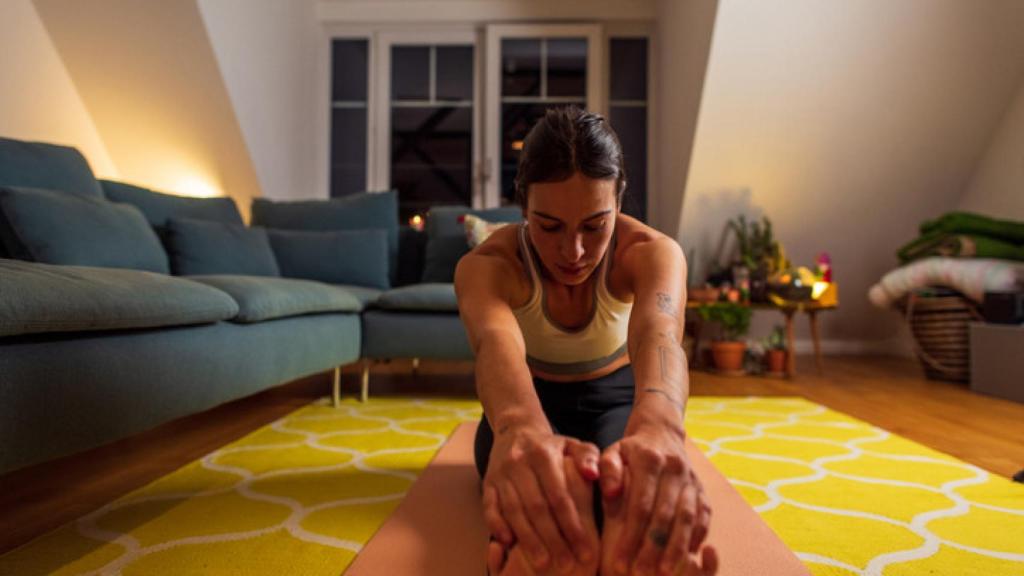 Una mujer practicando cozy cardio en casa.