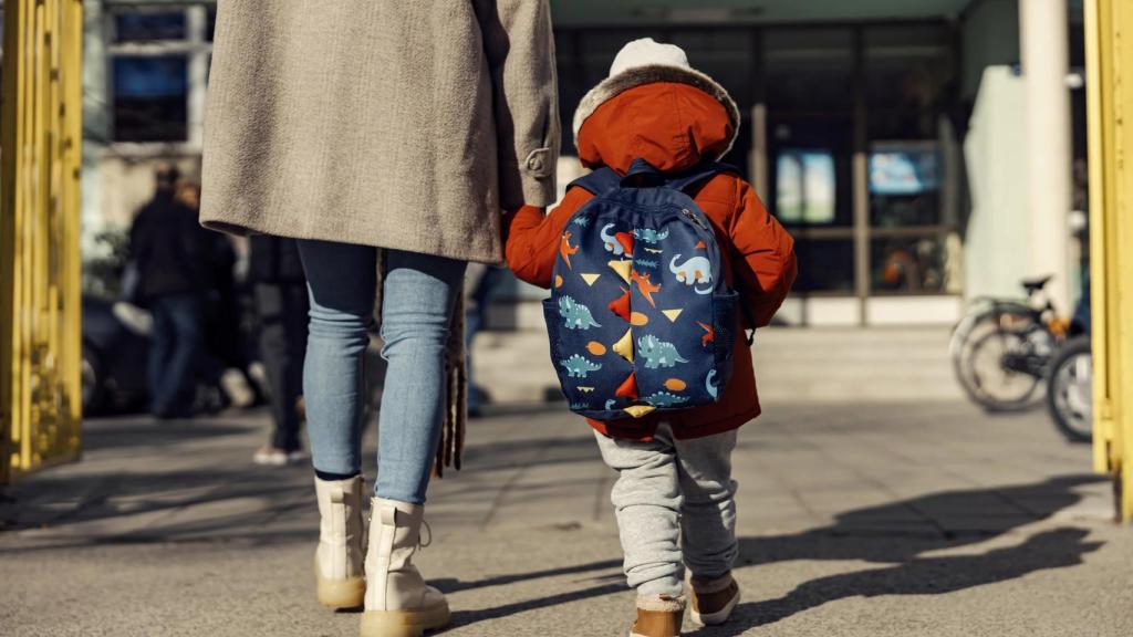 Una madre acude al colegio con su hijo.