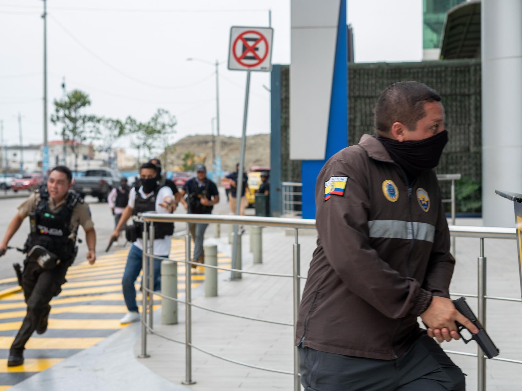 Policías persiguen a un delincuente cerca de la sede del canal de televisión TC, en Guayaquil (Ecuador).