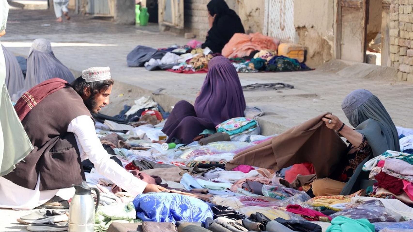 Mujeres afganas venden ropa usada al costado de la carretera, en una fotografía de archivo.