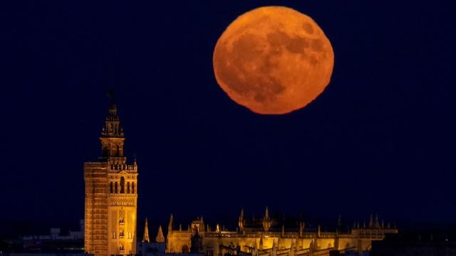 Imagen de una luna llena detrás de la Giralda y la catedral de Sevilla.