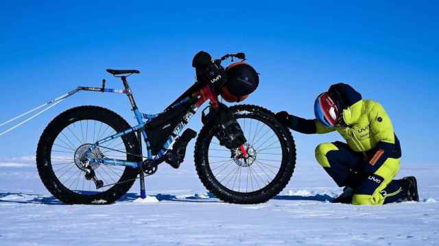 Omar di Felice junt a su bicicleta en la Antártida