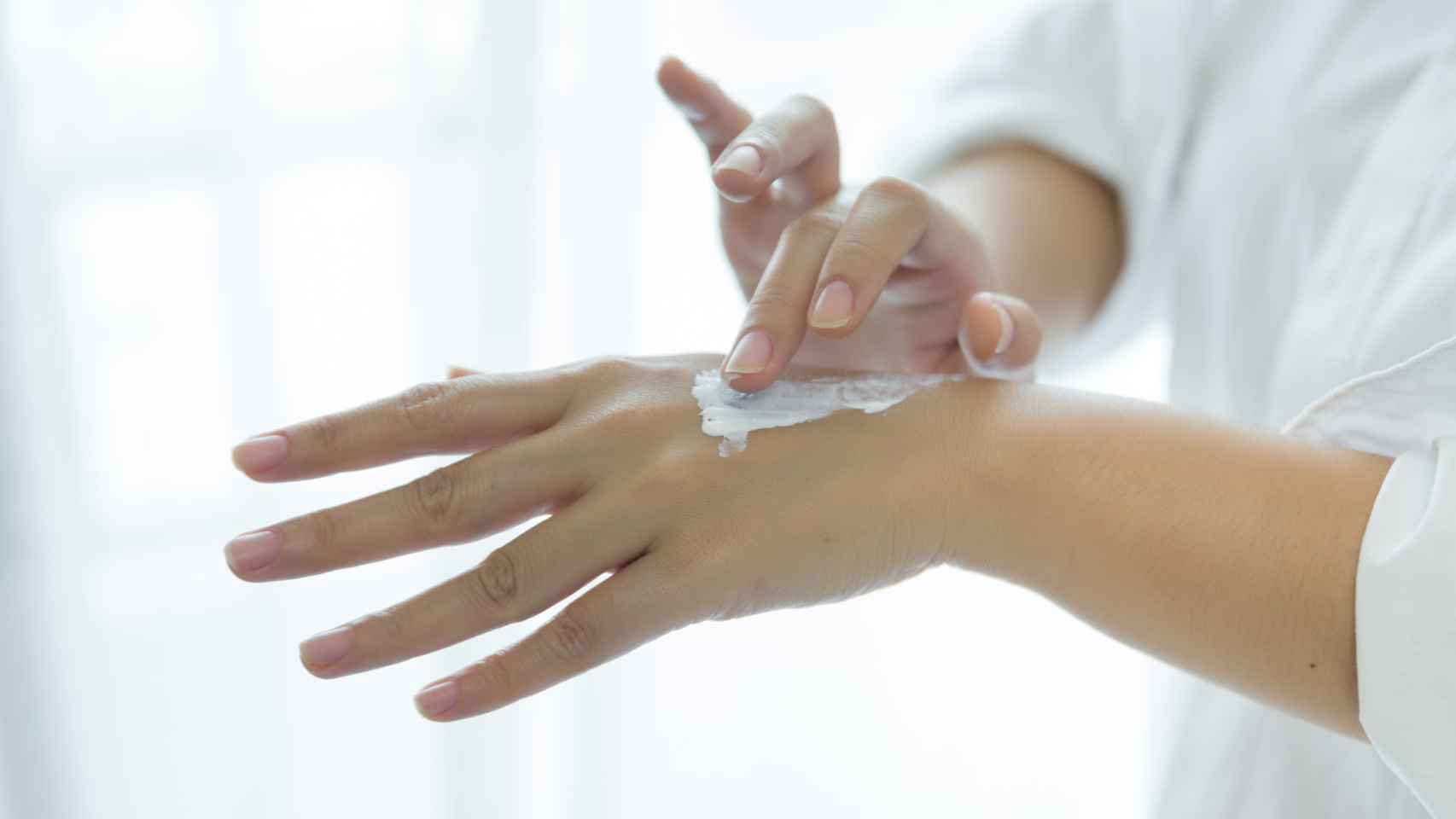 Una mujer aplicando crema de manos.