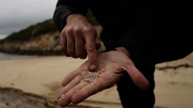 Un voluntario enseña los pellets tras recogerlos de la playa en Galicia.