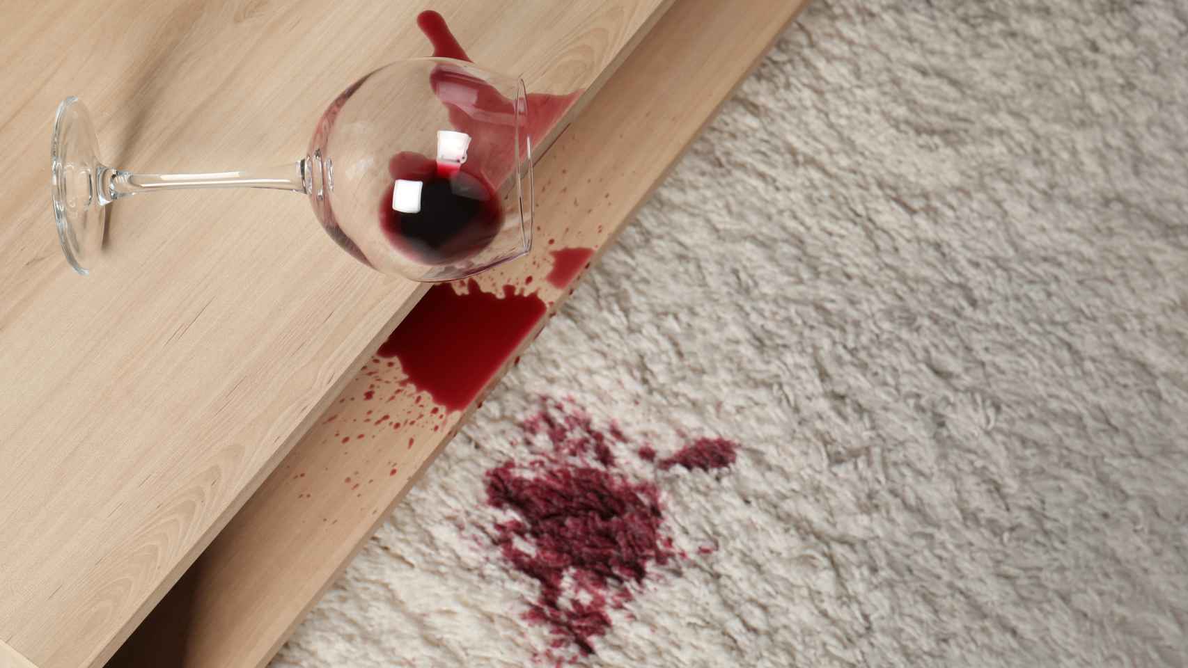 Una copa de vino derramada sobre una alfombra.