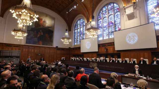 La gente se sienta dentro de la Corte Internacional de Justicia (CIJ) el día del juicio para escuchar una solicitud de medidas de emergencia de Sudáfrica. 11 de enero de 2024.