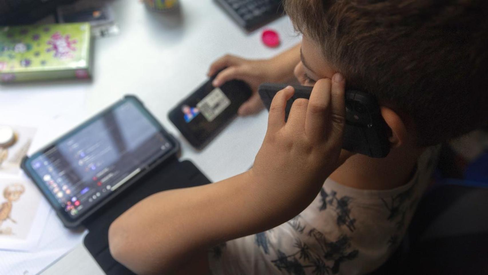 Un niño, con tres dispositivos en uso simultáneamente.