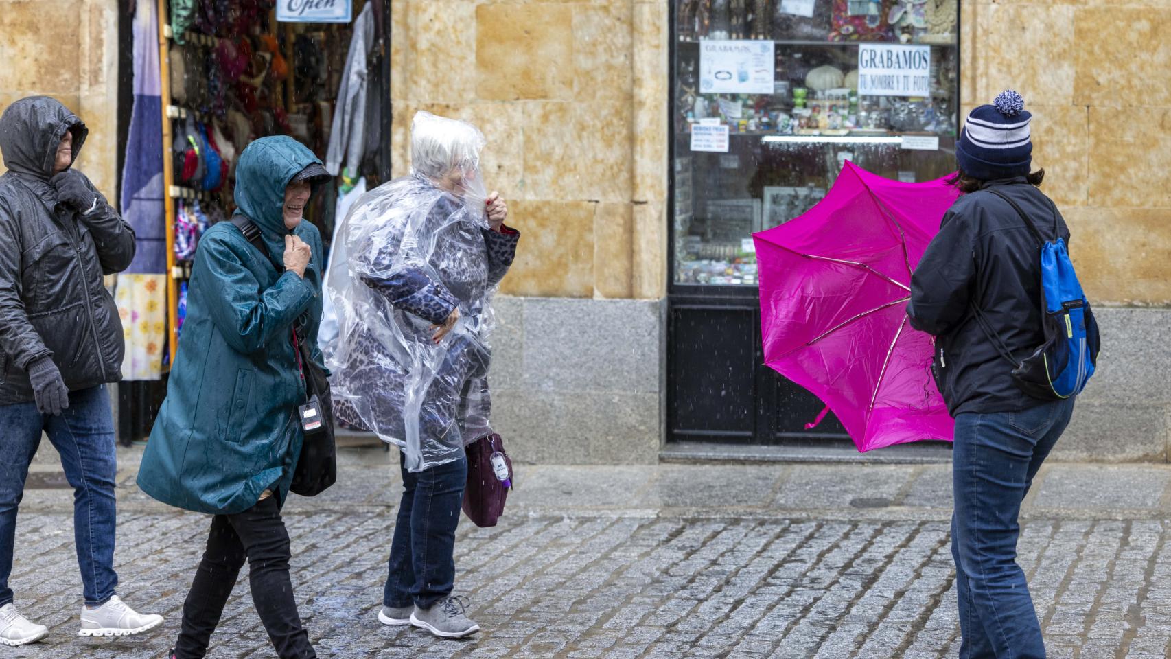 Imagen de unas personas protegiéndose de la lluvia en Salamanca