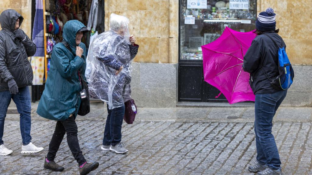 Imagen de unas personas protegiéndose de la lluvia en Salamanca