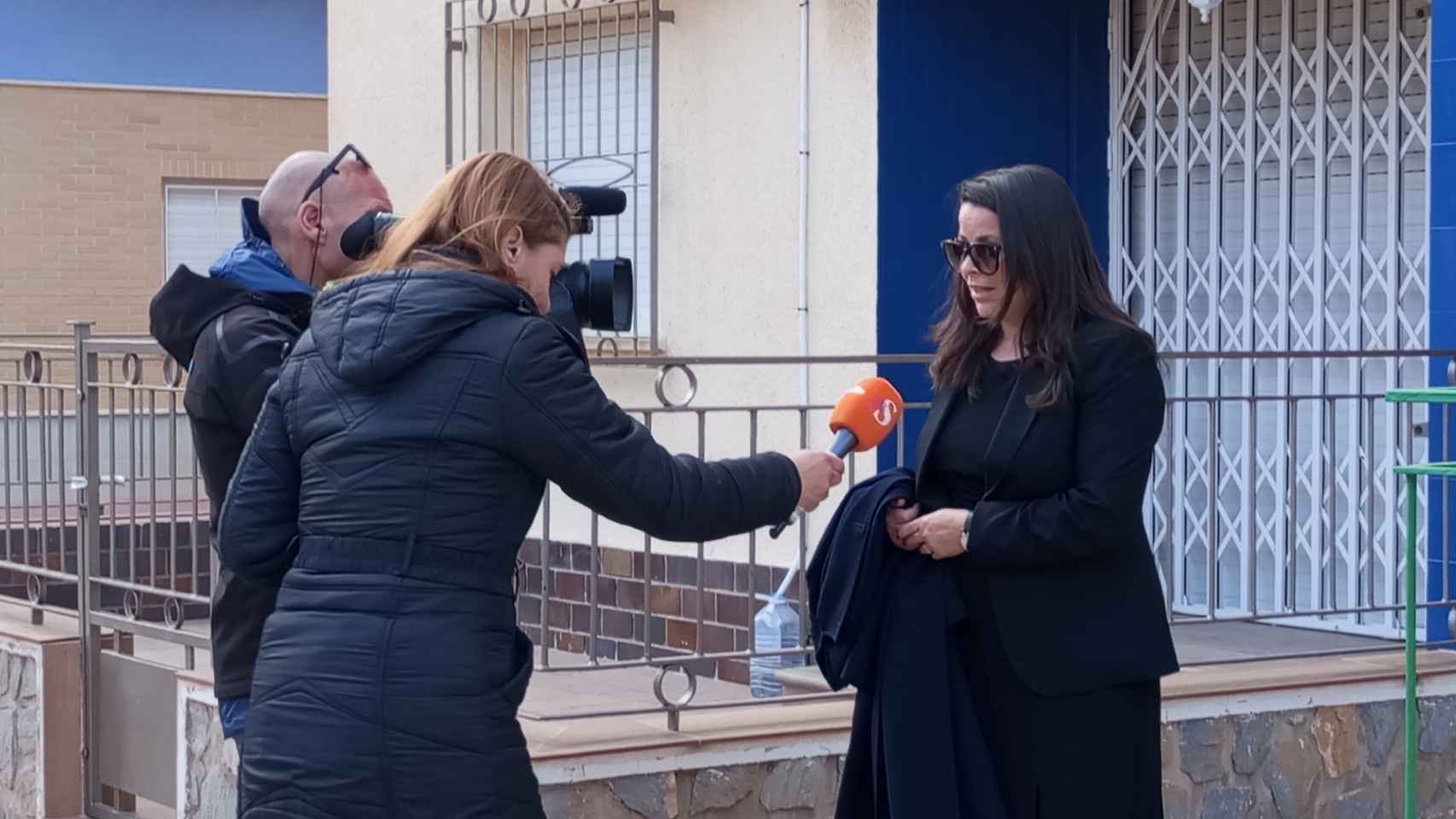 La abogada Verónica Ene, este viernes, atendiendo a unos periodistas de Antena 3 en la puerta del bloque de pisos donde residen los padres del menor de edad desaparecido.