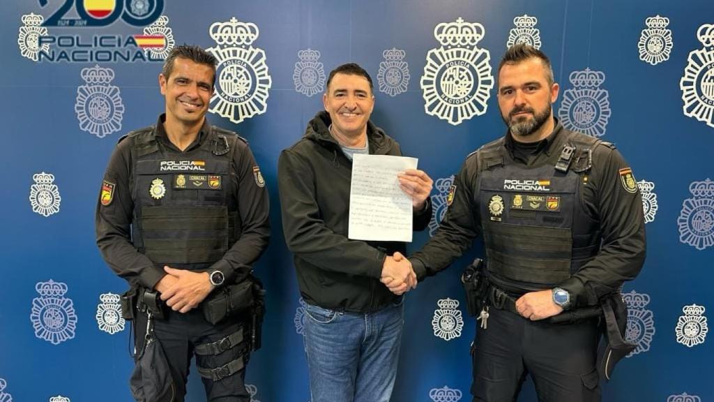 Los dos agentes y el hombre auxiliado con la carta de agradecimiento.