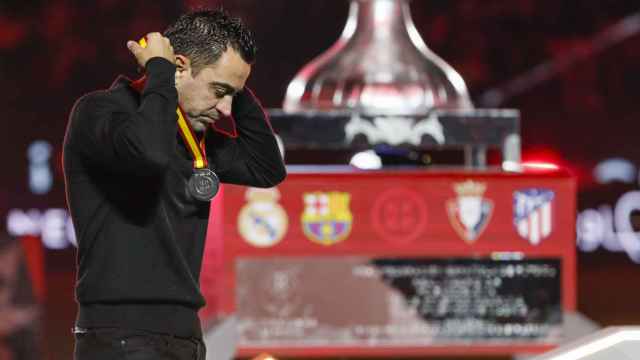 Xavi Hernández quitándose  la medalla de segundo clasificado de la Supercopa de España.