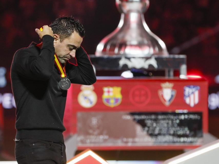 Xavi Hernández quitándose la medalla de segundo clasificado de la Supercopa de España.