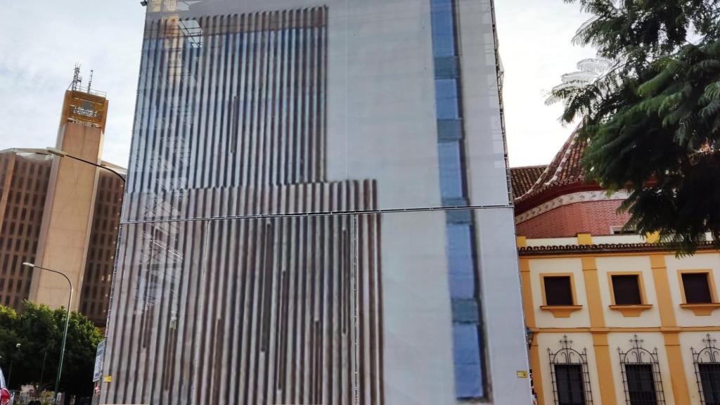 Una lona recreando la futura fachada de la casa hermandad de la Expiración cubre los andamios.